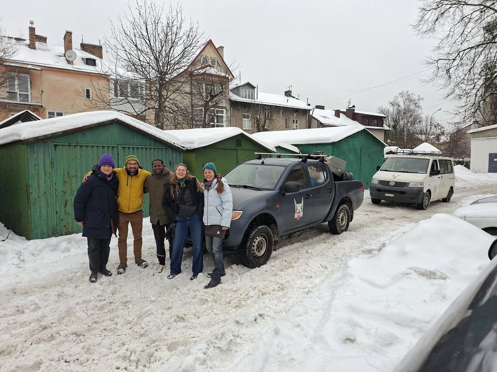 Freiwillige mit Pick-up und Transporter im verschneiten Hinterhof
